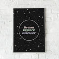 Sort plakat med stjerner og pasteltekst, der opfordrer til at drømme, udforske og opdage. Inspirerende vægkunst med kosmisk tema.