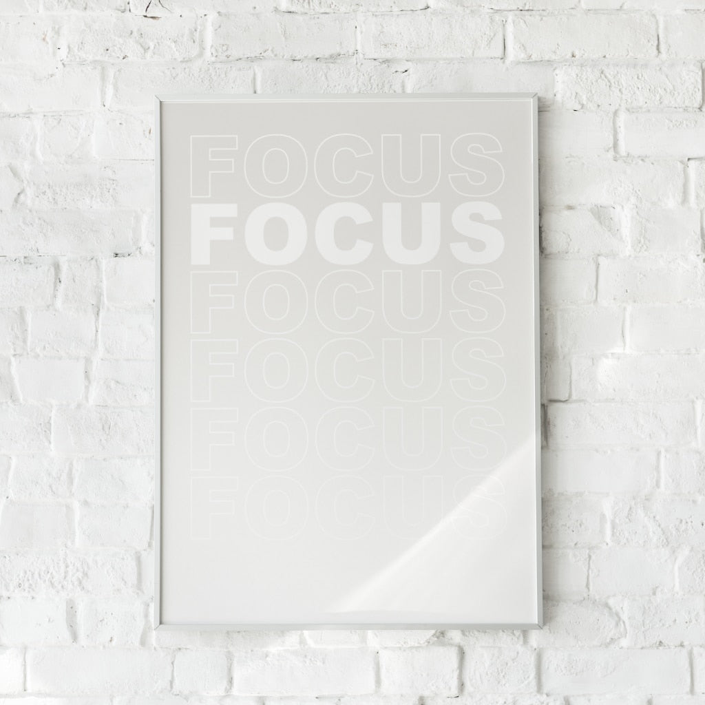 Minimalistisk plakat med ordet “FOCUS” gentaget i falmede hvide nuancer på en ren baggrund. Inspirerer til koncentration og ro.