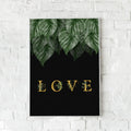 Sort plakat med grønne blade og gylden tekst “LOVE”.
