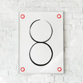 Minimalistisk plakat med to sorte cirkler og røde detaljer. Skaber balance og fokus.